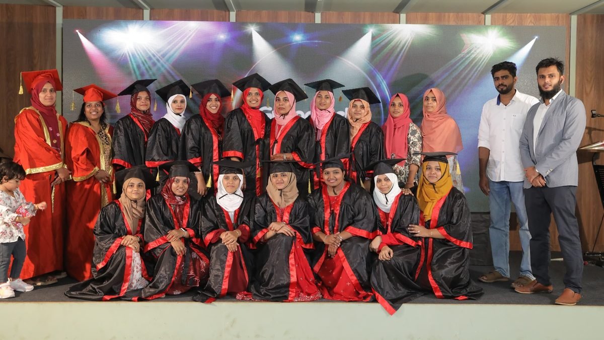 Montessori teacher trainees in graduation gowns with faculty